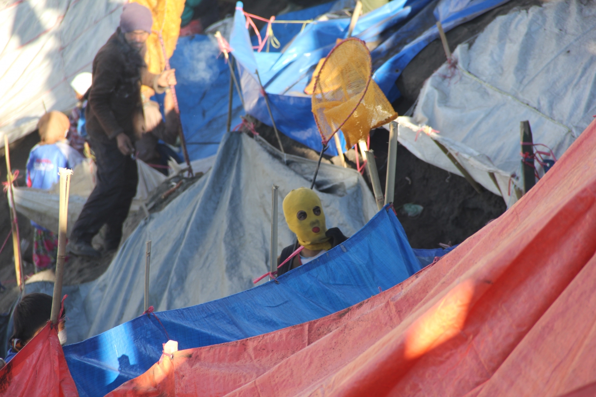 Masked precariat waiting inside the crate of Mount Bromo, East Java. (Photo: Etienne Turpin)